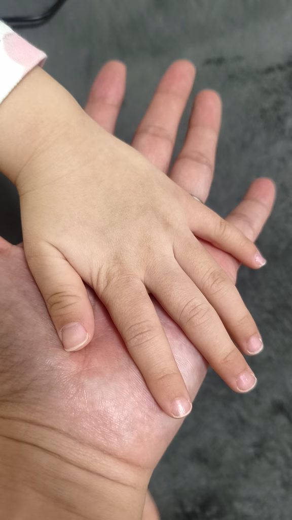 パパの手に5歳の女の子の手を重ねた写真
